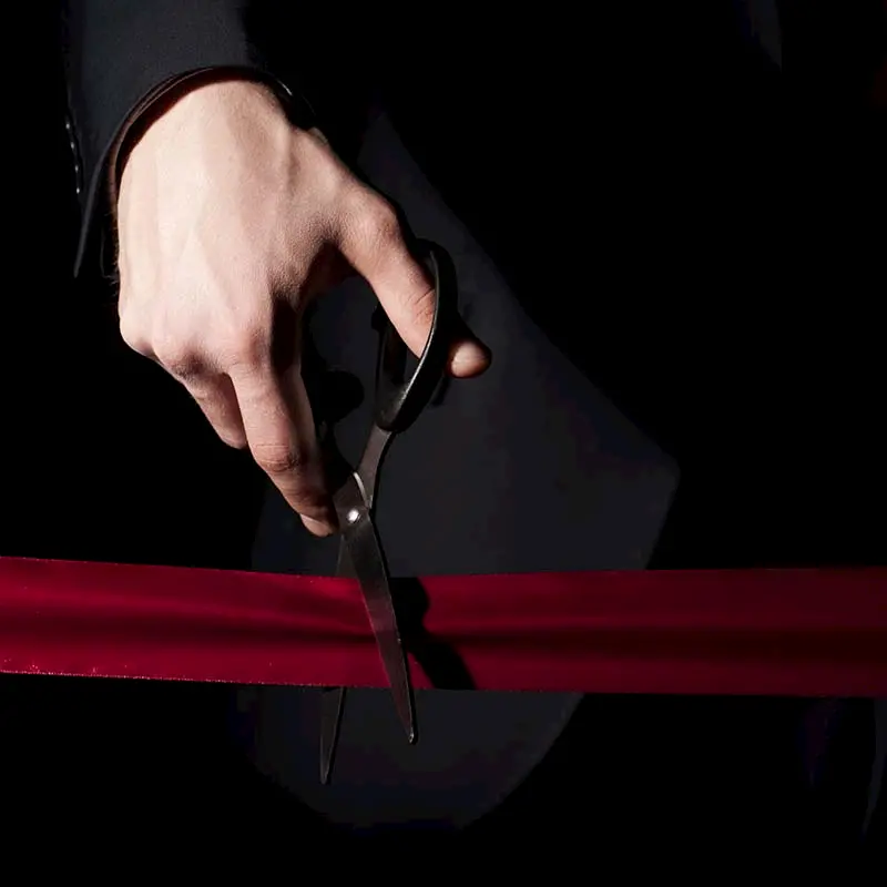 Homme qui coupe un ruban